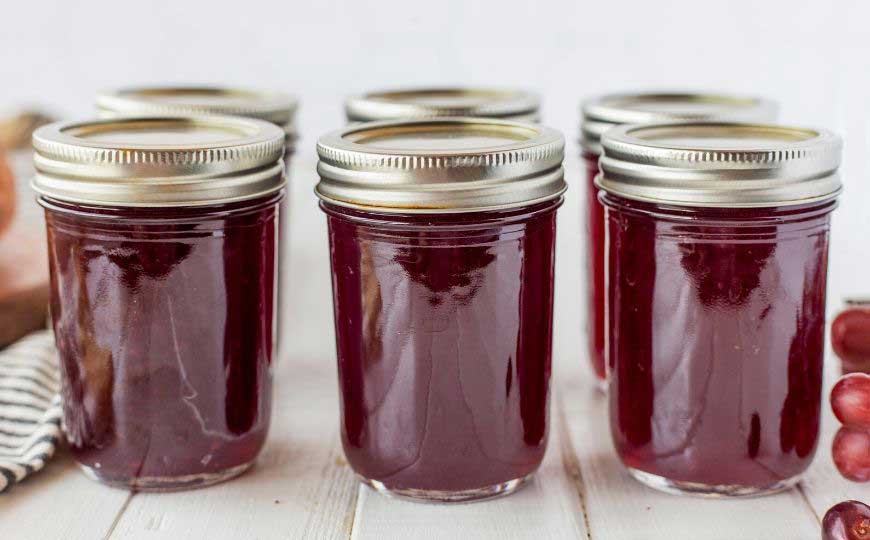 jars of grape jelly with lids in a row