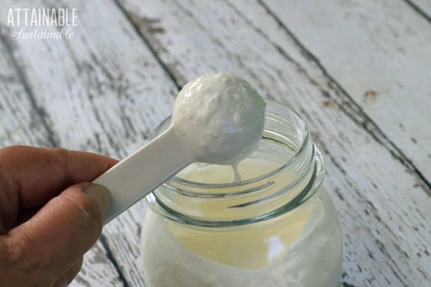 homemade sour cream curdling on a white spoon