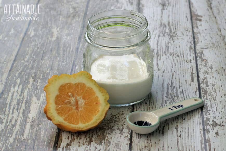 lemon, glass jar with cream, and a ceramic measuring spoon