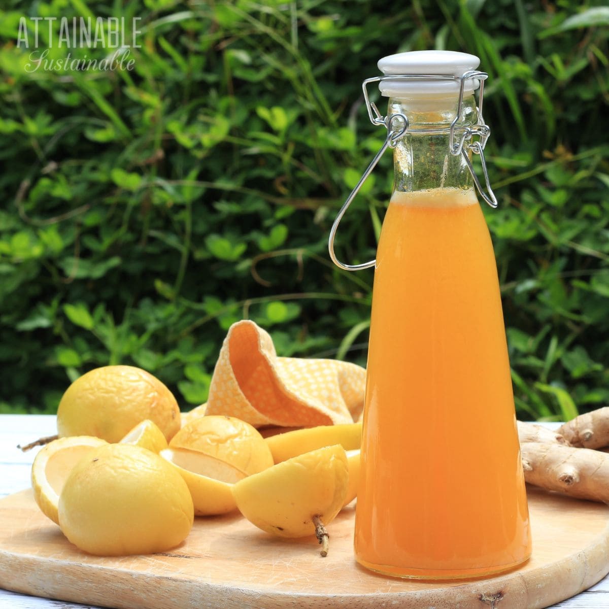 Orange colored liquid in a swingtop bottle with lilikoi rinds behind.