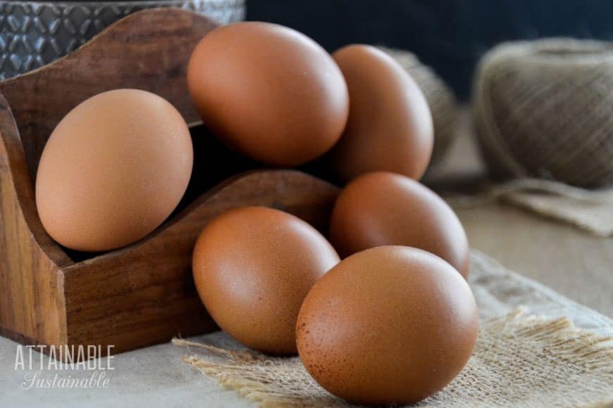 brown eggs stacked in a small wooden box