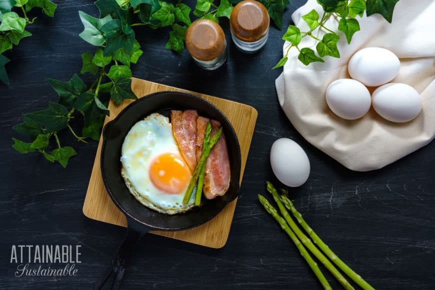 fried farmer's breakfast with canadian bacon and asparagus in a cast iron pan