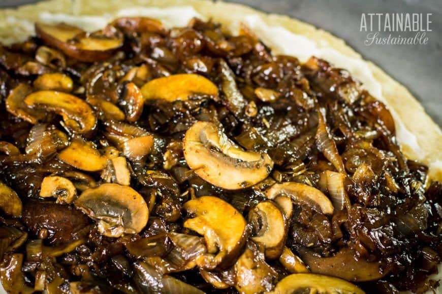 mushrooms and onions spread on a flat pie crust
