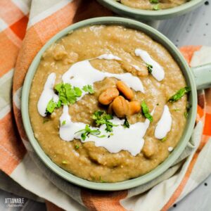 bowl of refried beans from above, garnished with sour cream and cilantro.