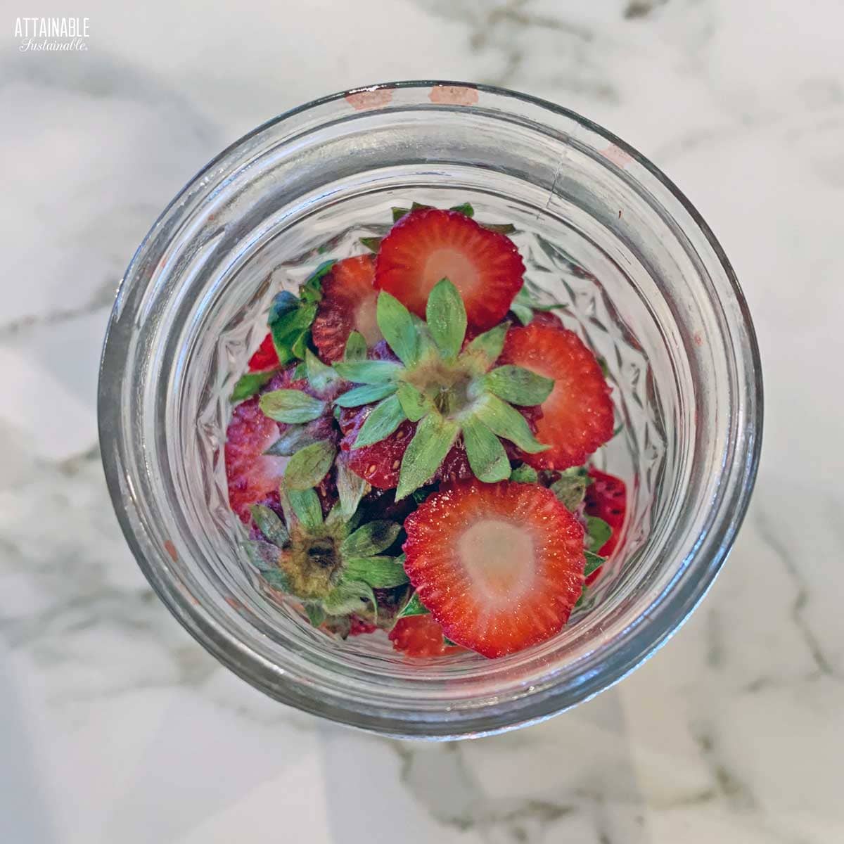 strawberry hulls in a glass jar from above. 