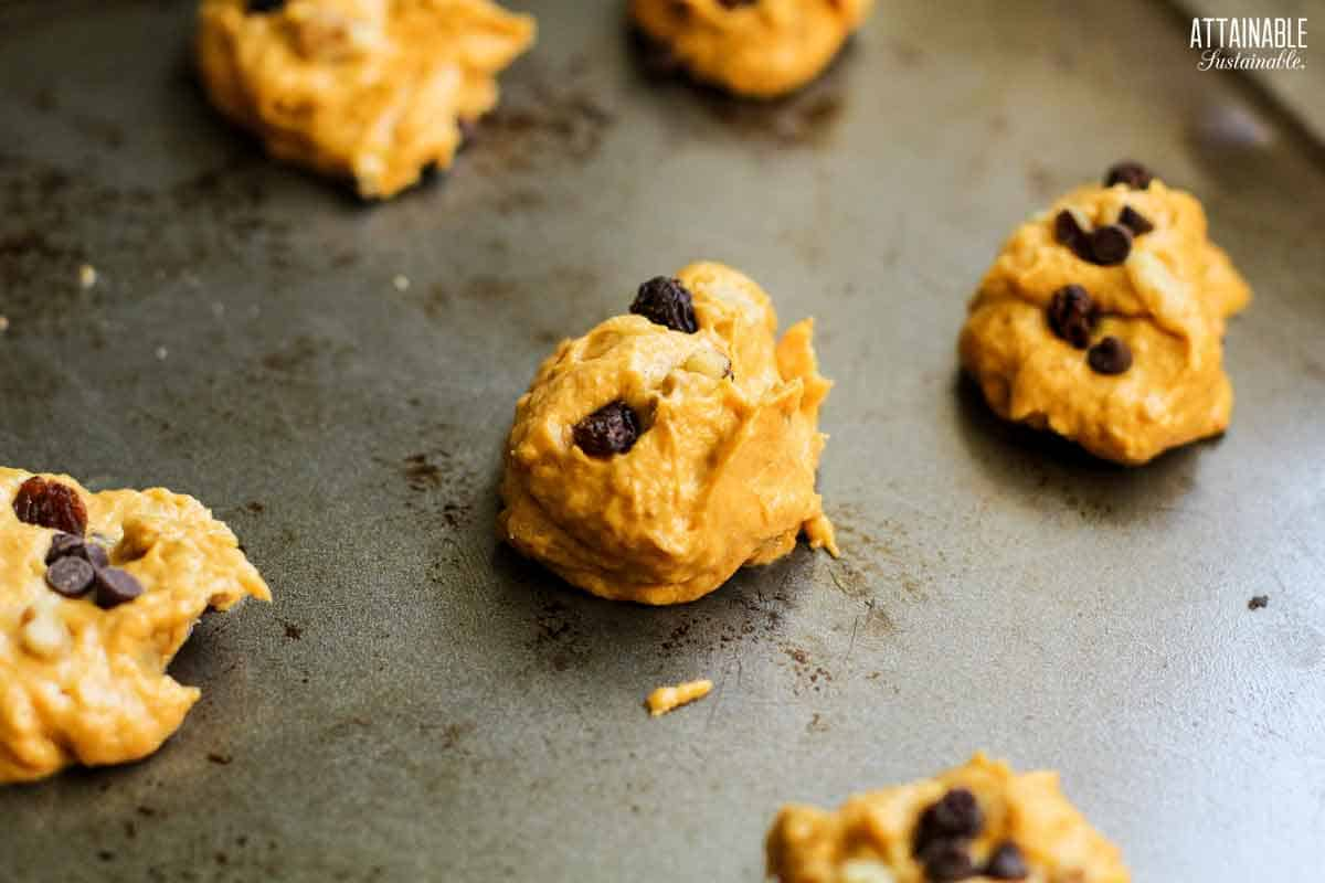 uncooked balls of cookie dough on a baking sheet.