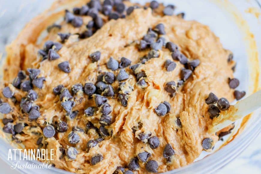 adding chocolate chips to muffin batter in a bowl