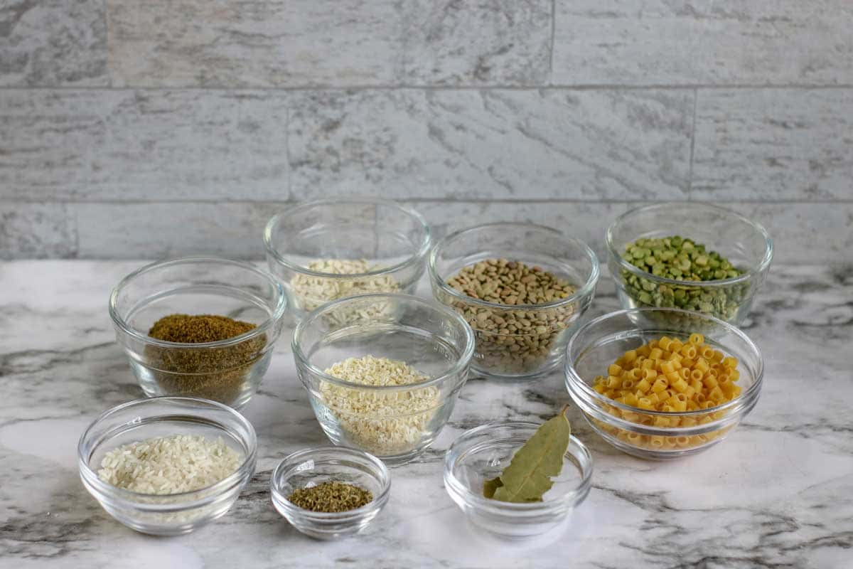 individual ingredients for soup in a jar in glass dishes.