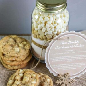 layered ingredients in a jar of ready to bake cookie mix with baked cookies.