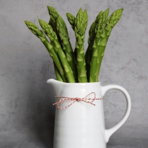 asparagus spears in a white decorative pitcher.