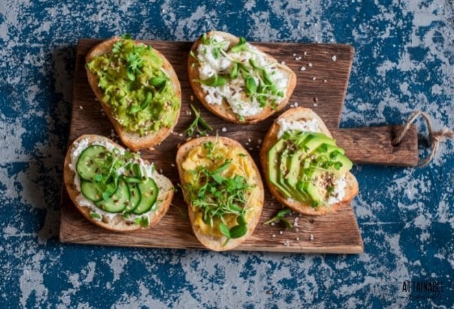 5 slices of bread topped with cucumbers, greens, and avocado