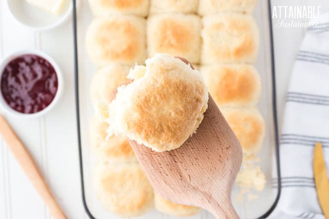 pull apart roll on a wooden spatula with a pan full in the background