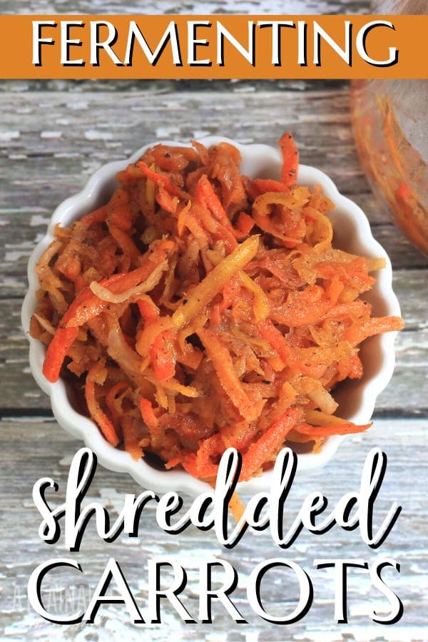 white scalloped bowl full of orange carrot shreds, from above.