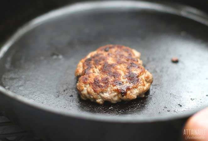 cooked sausage patty in a cast iron pan