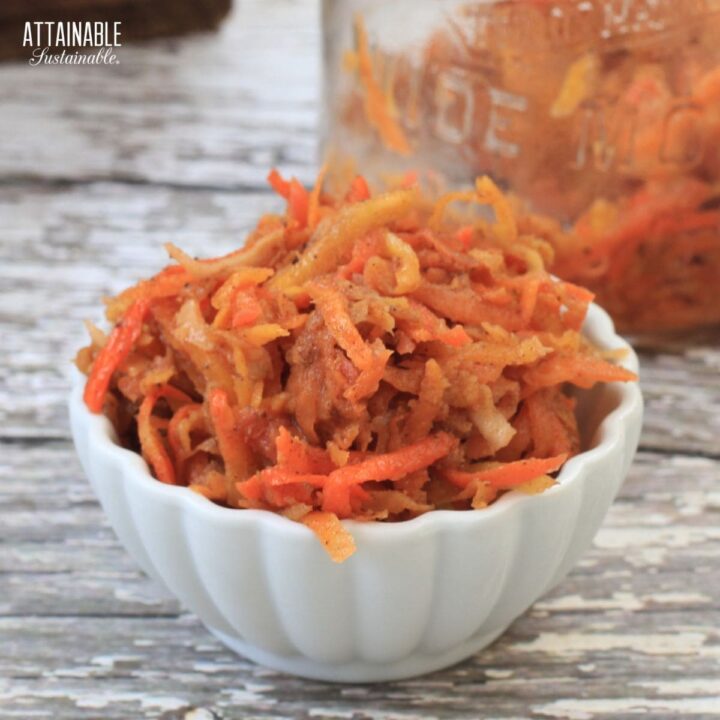 white scalloped bowl full of orange carrot shreds.