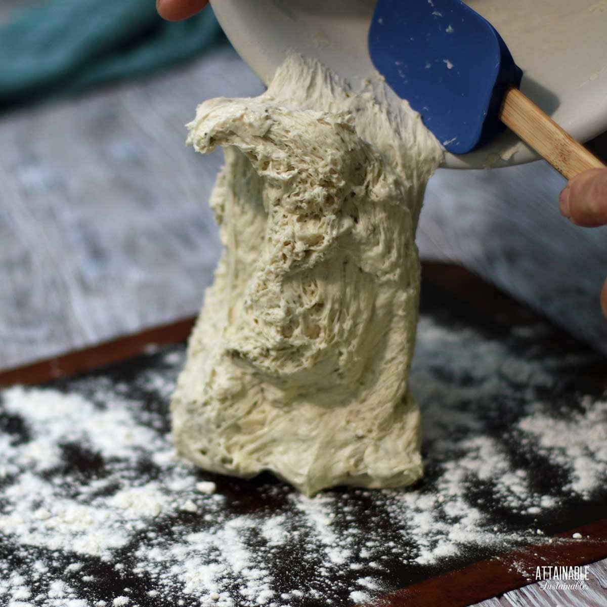 sticky no knead bread dough being transferred to a floured surface.