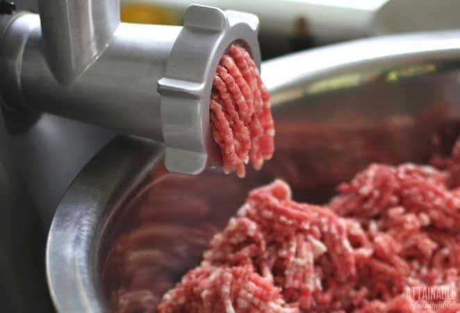 close up of pork meat coming out of a grinder