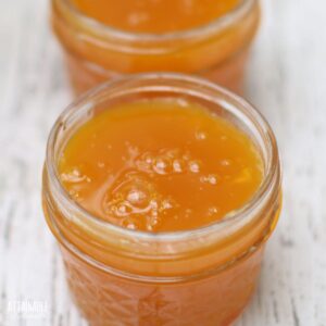 bright orange passion fruit jelly in 1/4 pint jars, lids off.