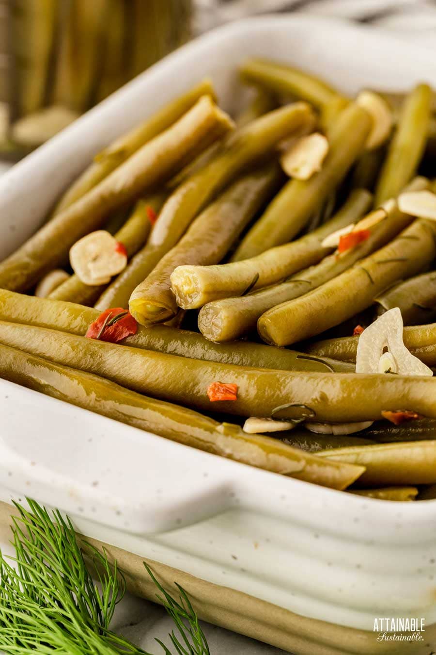 white pottery tray with pickled green beans ready to serve.