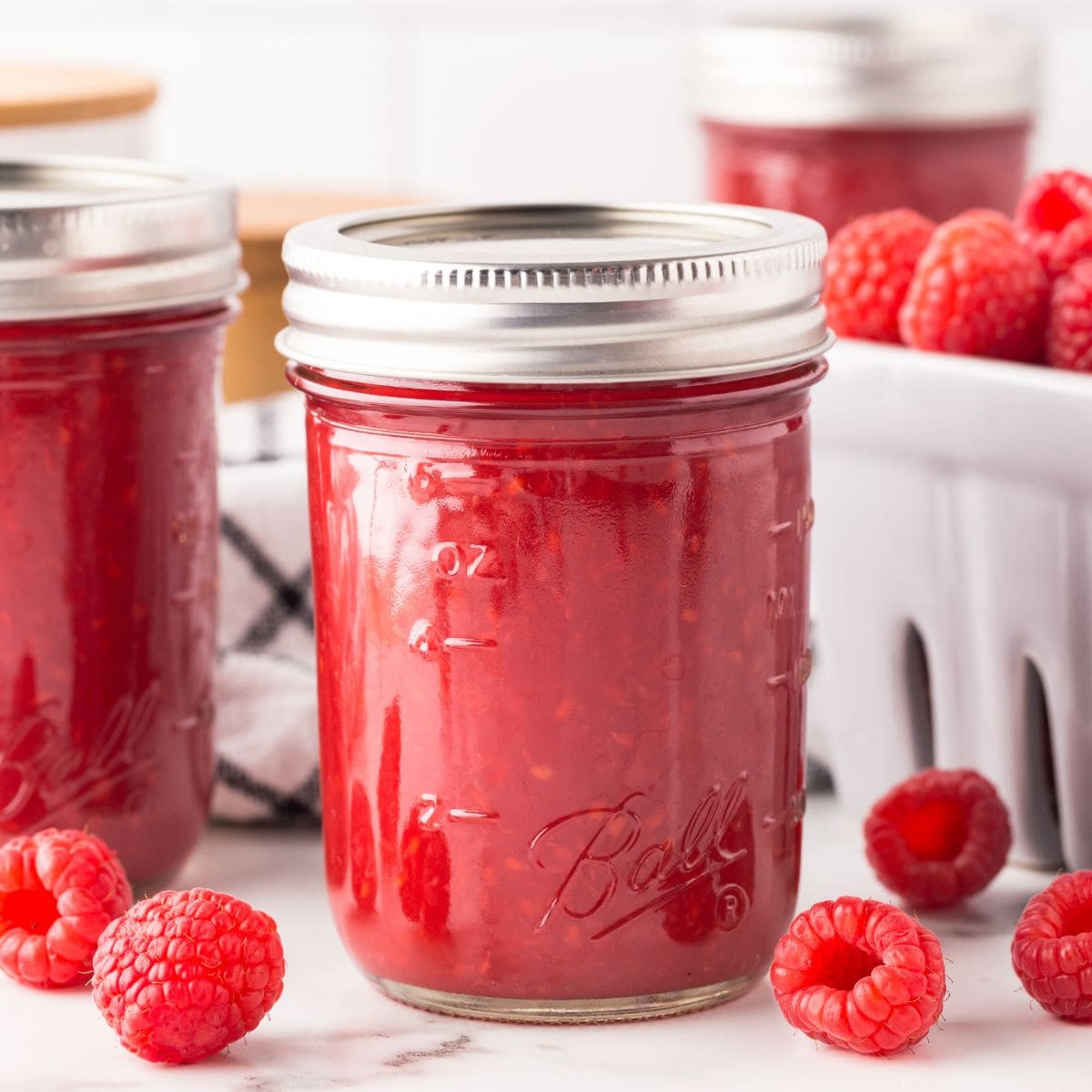 Jars of raspberry puree with lids and rings in place.
