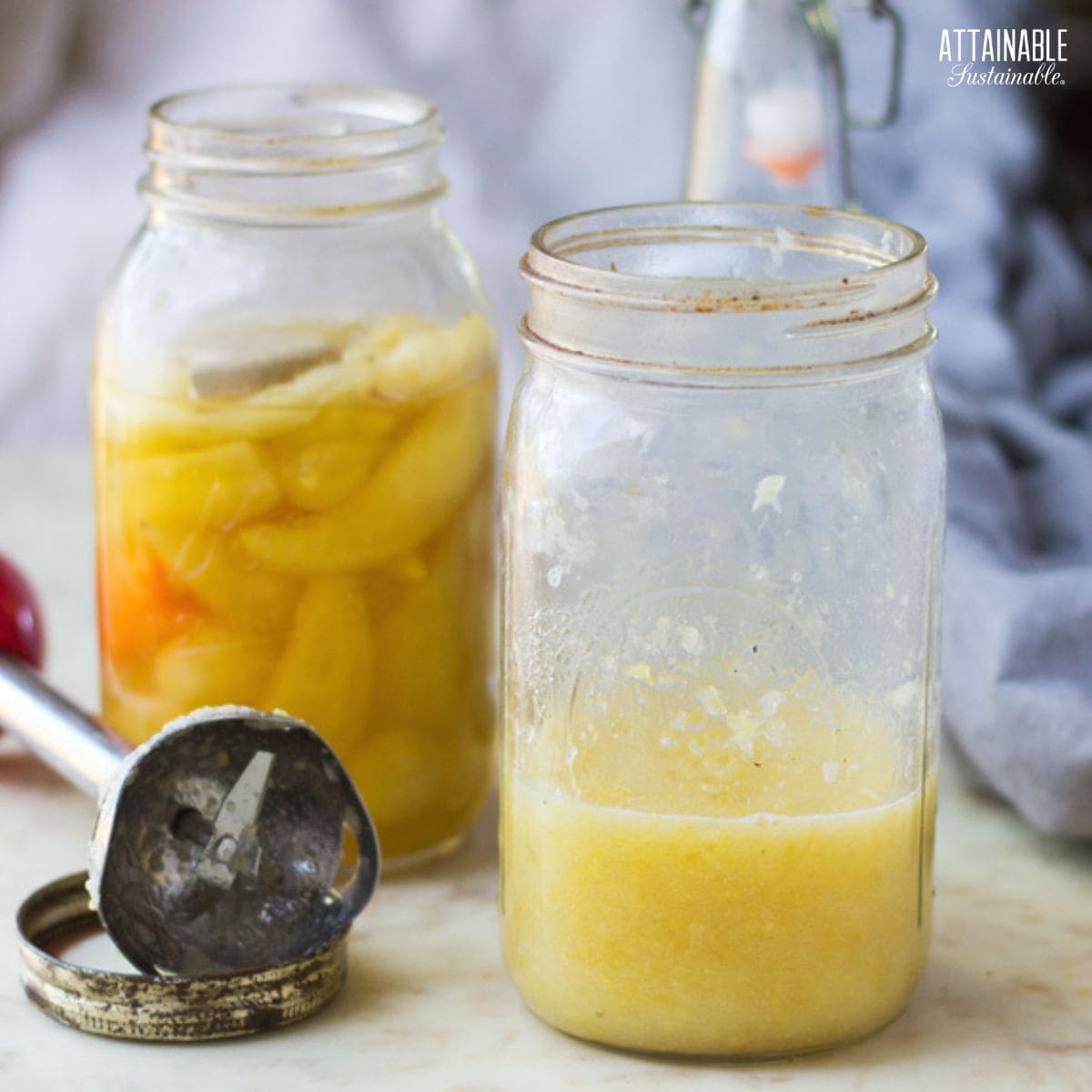 canning jar full of whole, yellow banana peppers, behind jar half full of blended hot sauce.