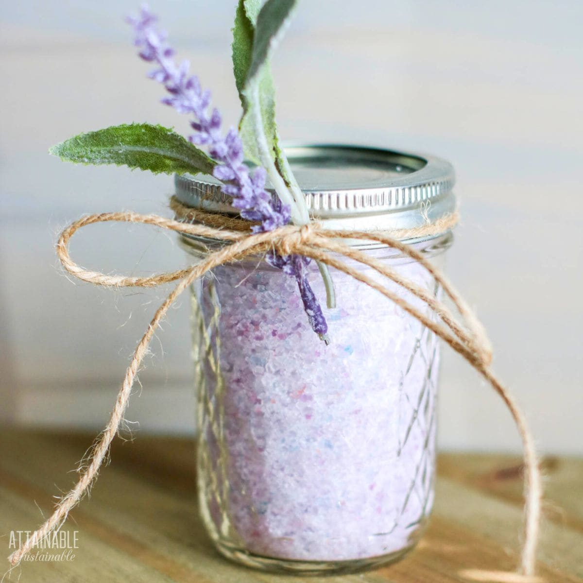 short canning jar with purple bath salts tied with twine.
