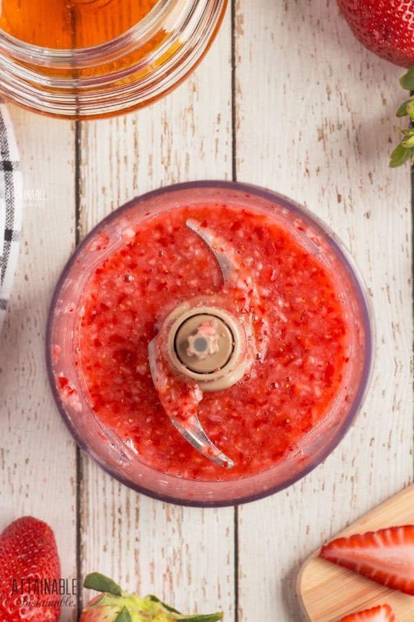 strawberries chopped in a food processor bowl with blade showing