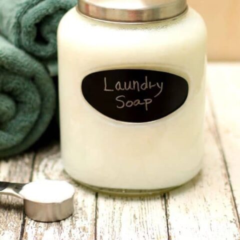 glass jar with white laundry soap and rolled green towels