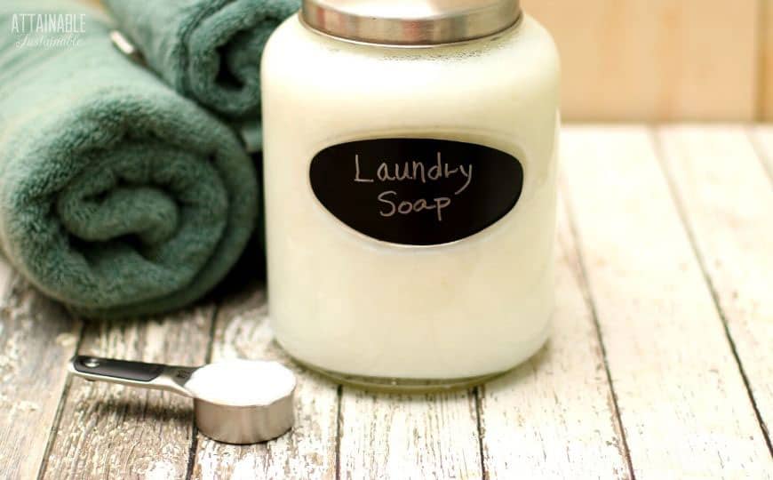 glass jar with white laundry soap and rolled green towels