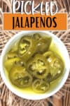 slices of pickled jalapeno peppers in a white bowl from above