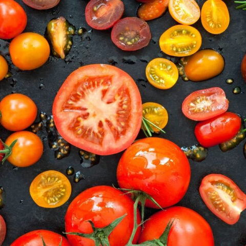 various heirloom tomatoes on a black background