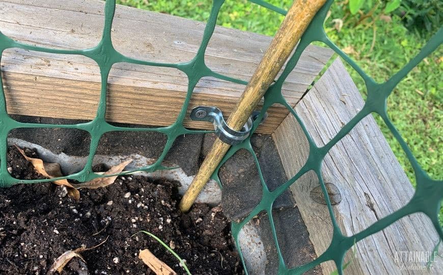 close up of pipe hanger with a stick of bamboo in it