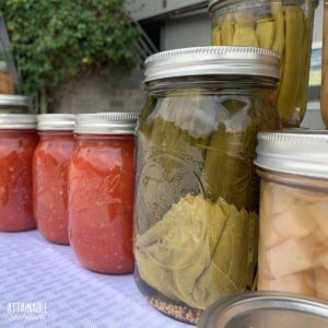 pint and quart size canning jars full of various preserved foods.