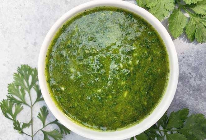 green cilantro sauce in a white dish from above