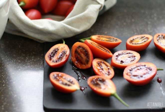 tamarillo fruit, cut in half, on a black cutting board