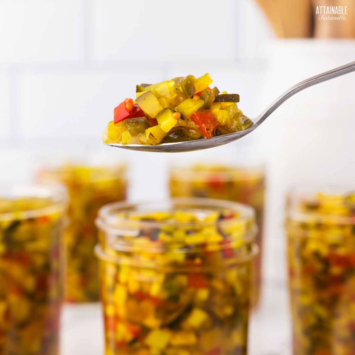spoonful of zucchini relish, jars in background.