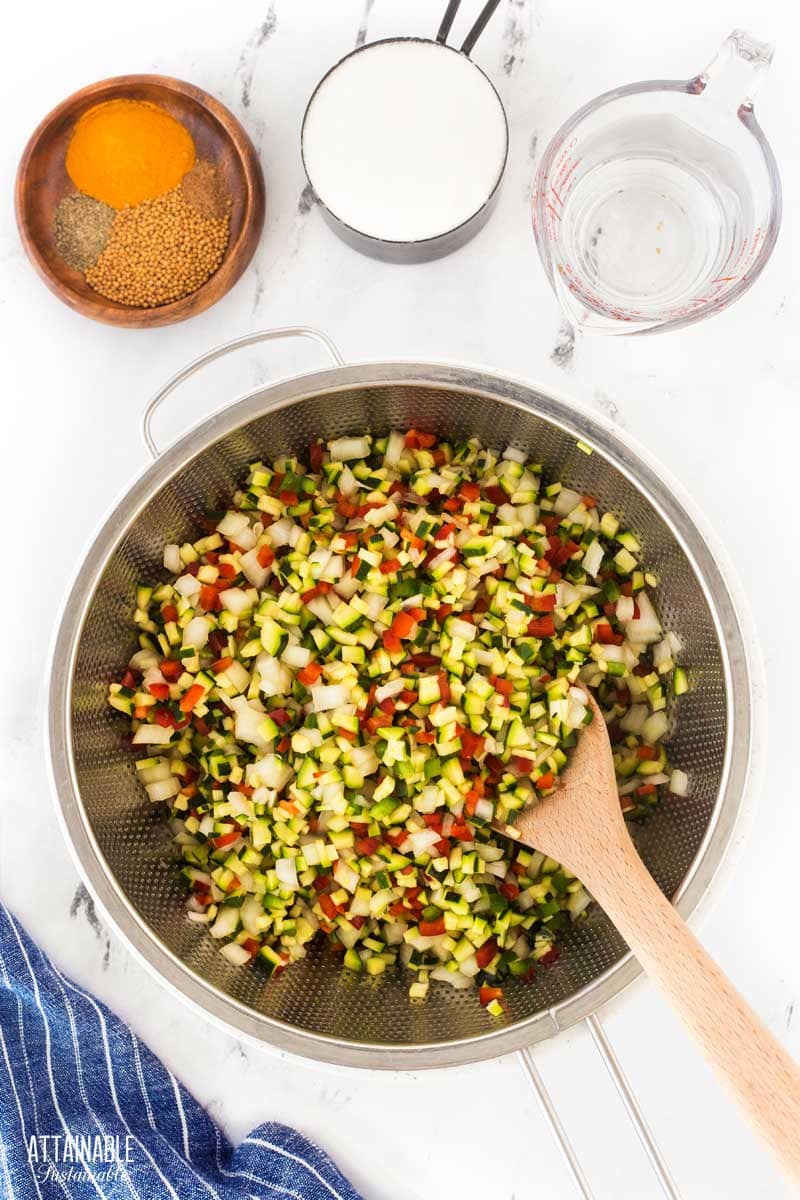 colander full of chopped vegetables.