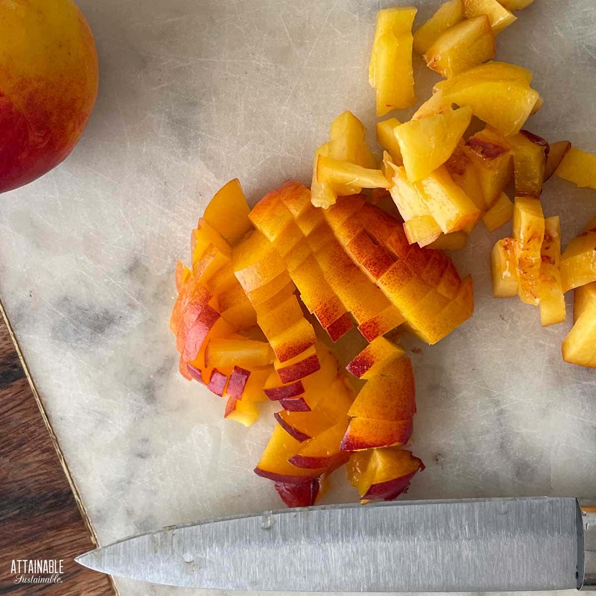 Chopped peaches on a marble cutting board.