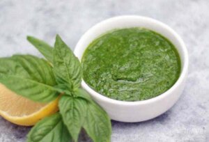 green basil sauce in a white bowl