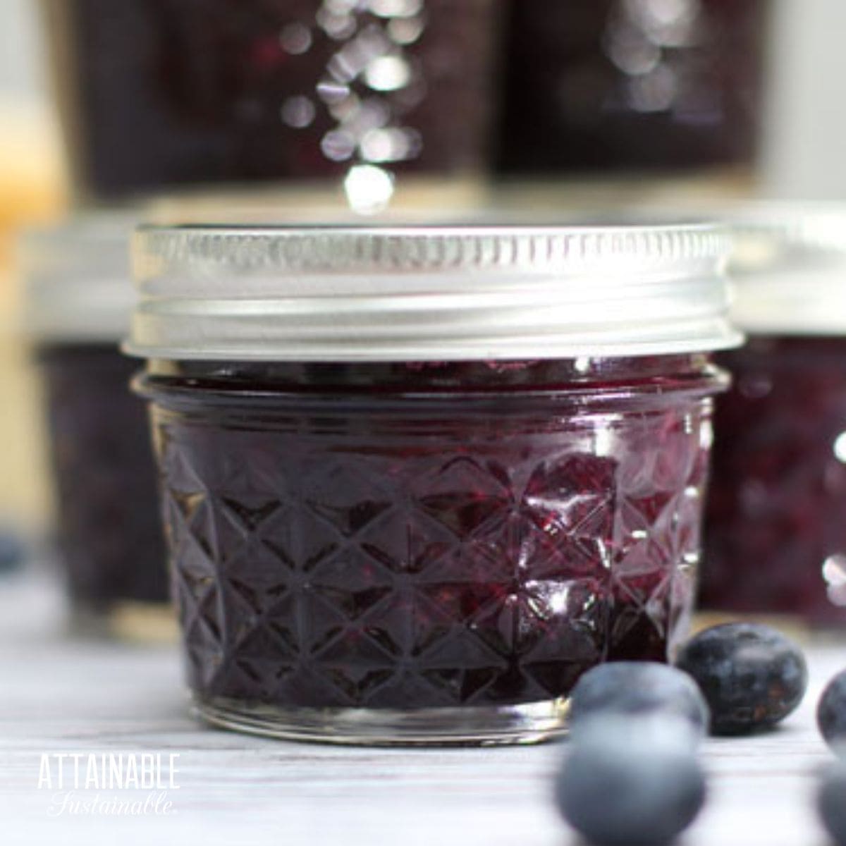 small jar of homemade blueberry jam, more in background.