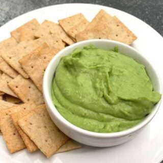 fava bean hummus in a white bowl with crackers