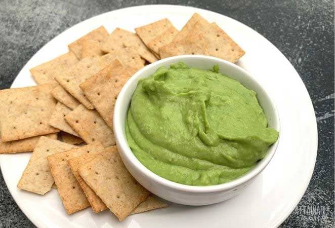 fava bean hummus in a white bowl with crackers