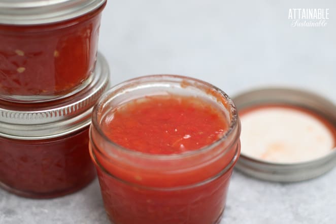 jars of red jam, one with lid off