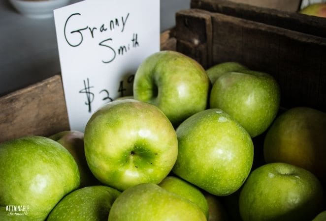 granny smith apples in a pile with a price sign