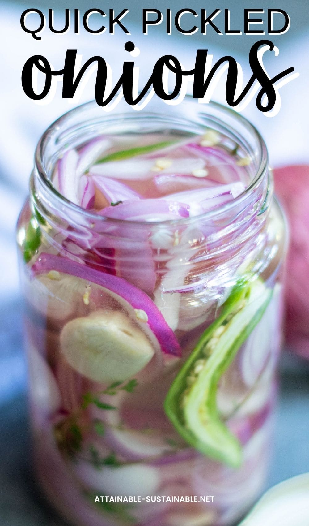 glass jar with open lid, sliced red onions, pepper and garlic visible 