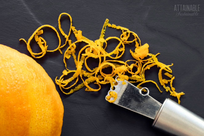 citrus zester on a black background with orange and zest