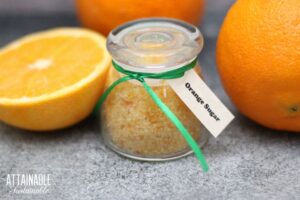 glass jar with orange flavored sugar and a green ribbon
