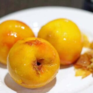 3 peeled peaches on a white plate