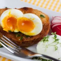 soft boiled egg on a plate with toast and radish garnish
