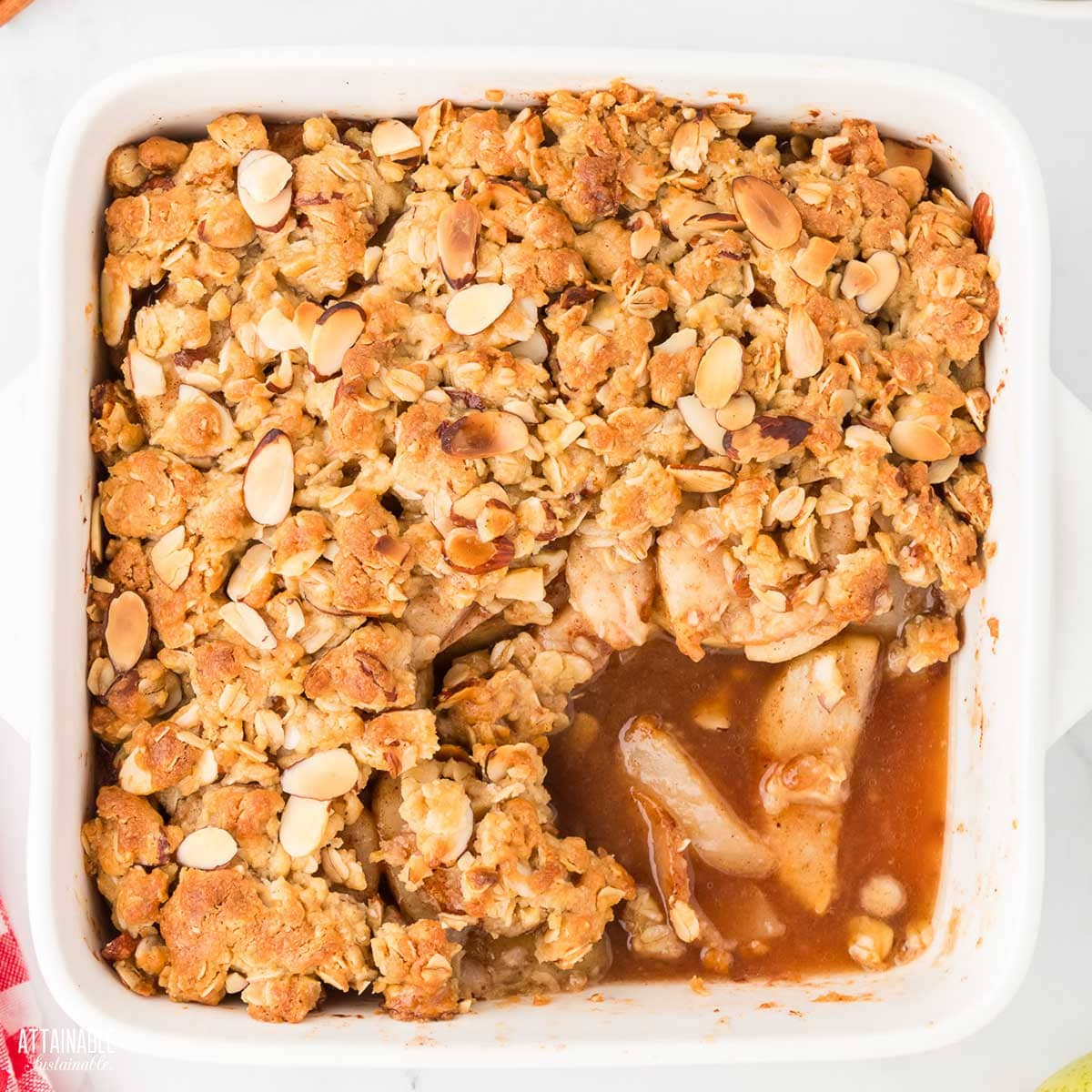 Baked pear crisp with a serving scooped out.